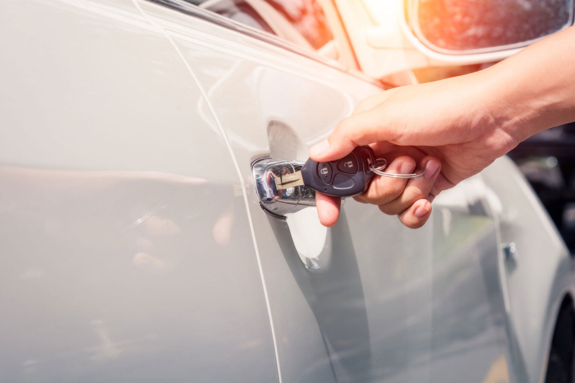 Hand opening a car door using a key