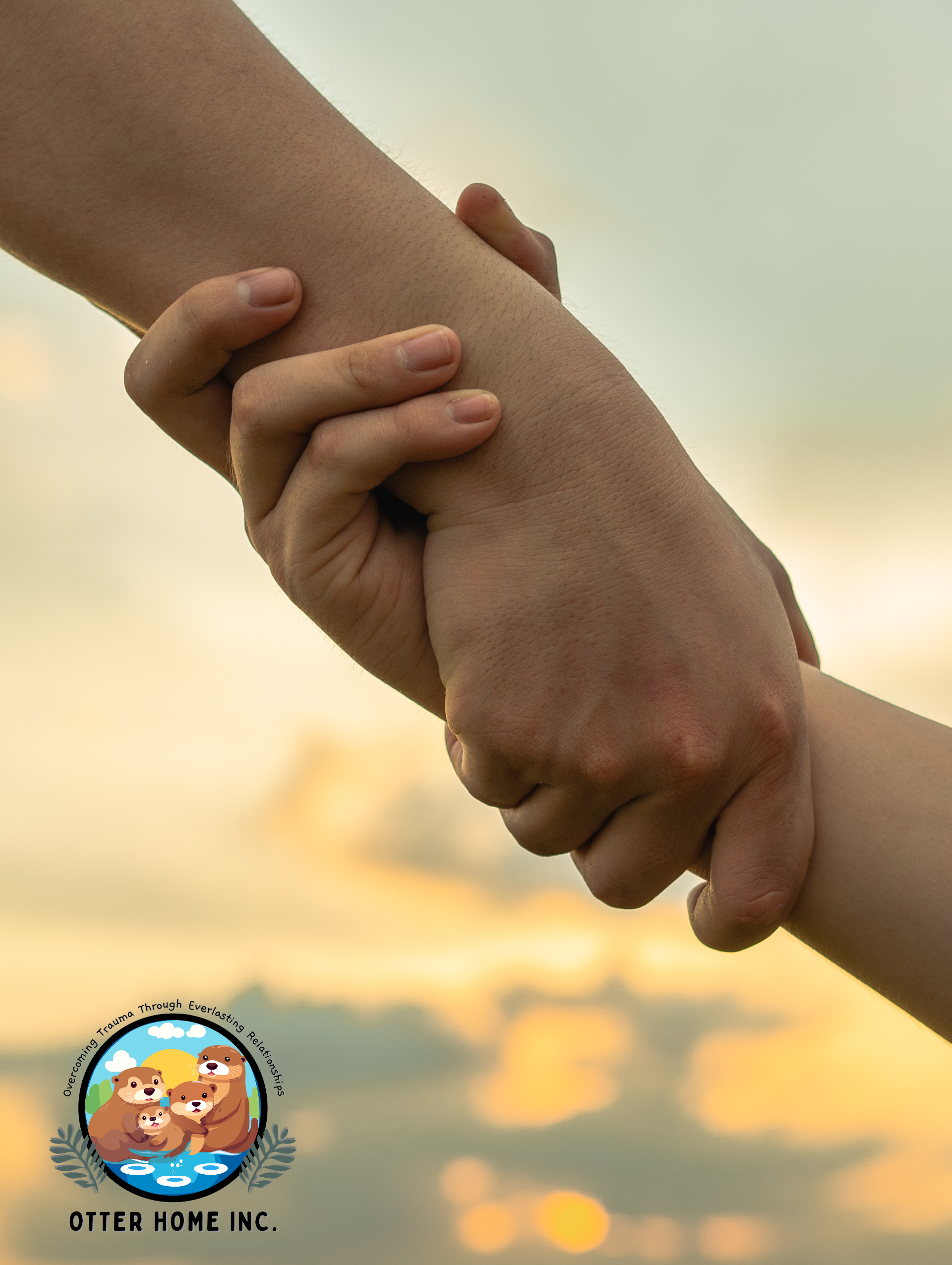 A person is holding a child 's hand in front of a cloudy sky.