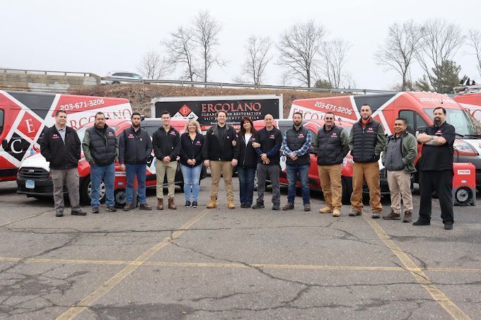 A group of people are posing for a picture in a parking lot.