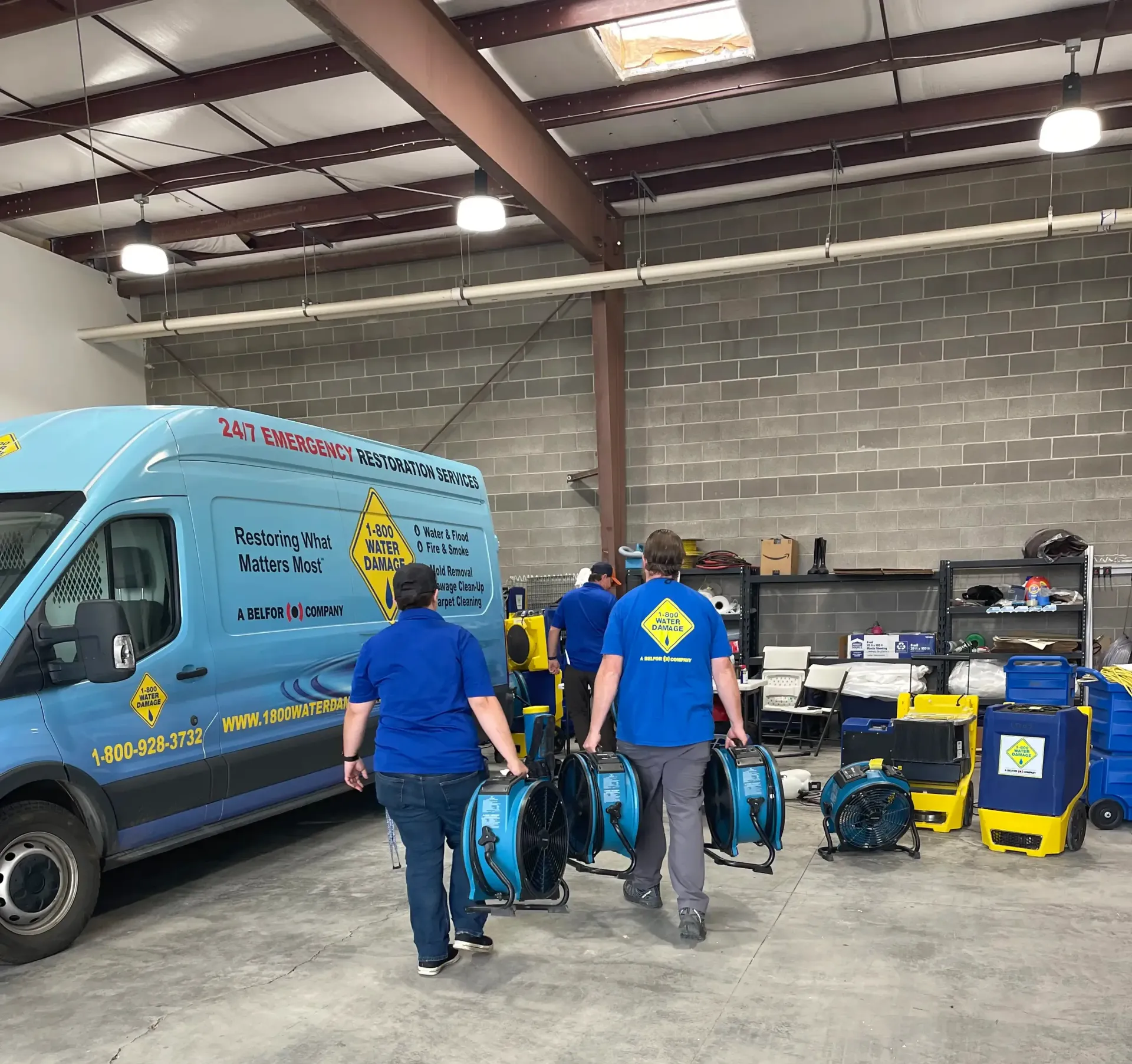 A group of people are walking towards a van in a garage.