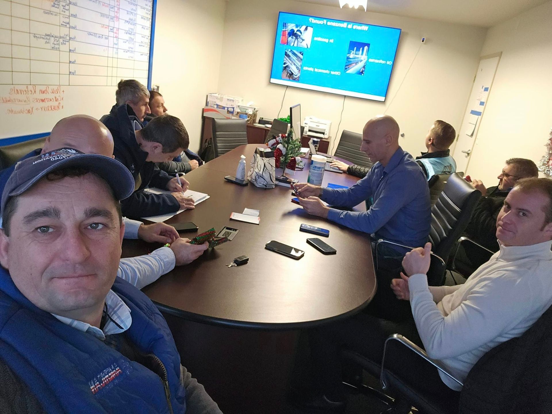 A group of men are sitting around a table in a conference room.