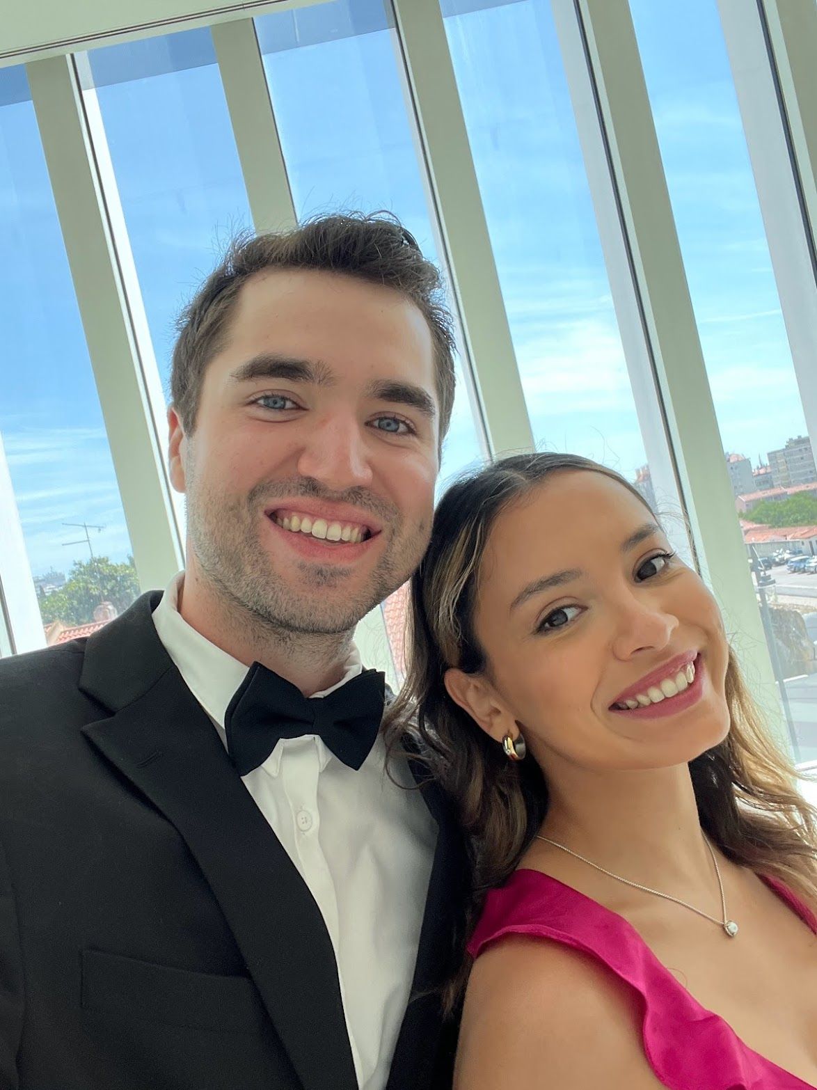 A man in a tuxedo and a woman in a pink dress are posing for a picture.