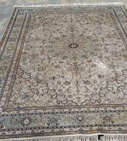 A rug is sitting on top of a concrete floor.