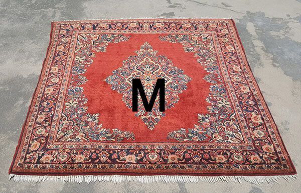 A red rug with the letter m on it