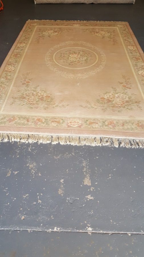 A large rug is sitting on top of a concrete floor.