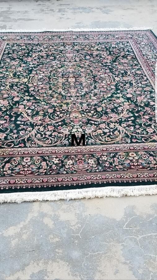 A rug with the letter m on it is sitting on the ground.