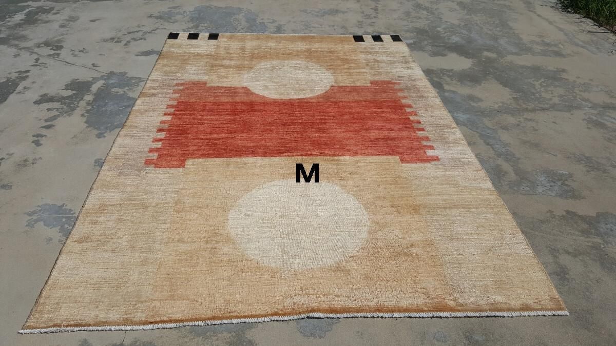 A rug with the letter m on it is sitting on the ground.