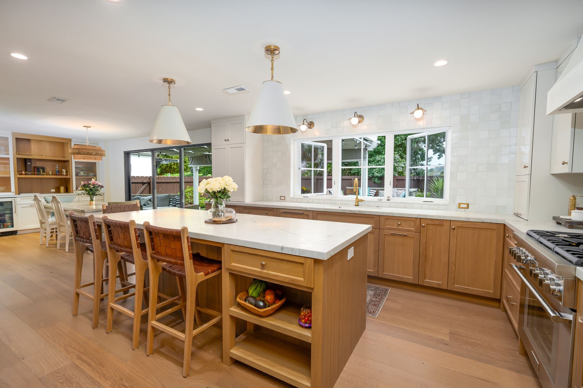 Spacious, bright kitchen with wooden cabinets, island, and modern gold accents.