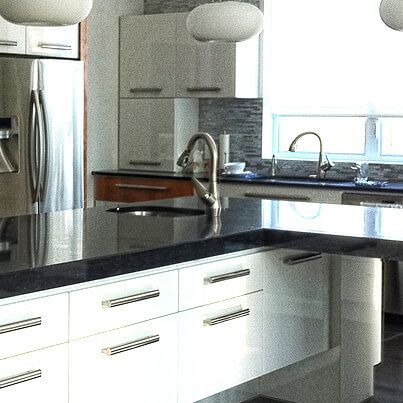 Cuisine moderne avec comptoir foncé, armoires blanches et appareils électroménagers en acier inoxydable.
