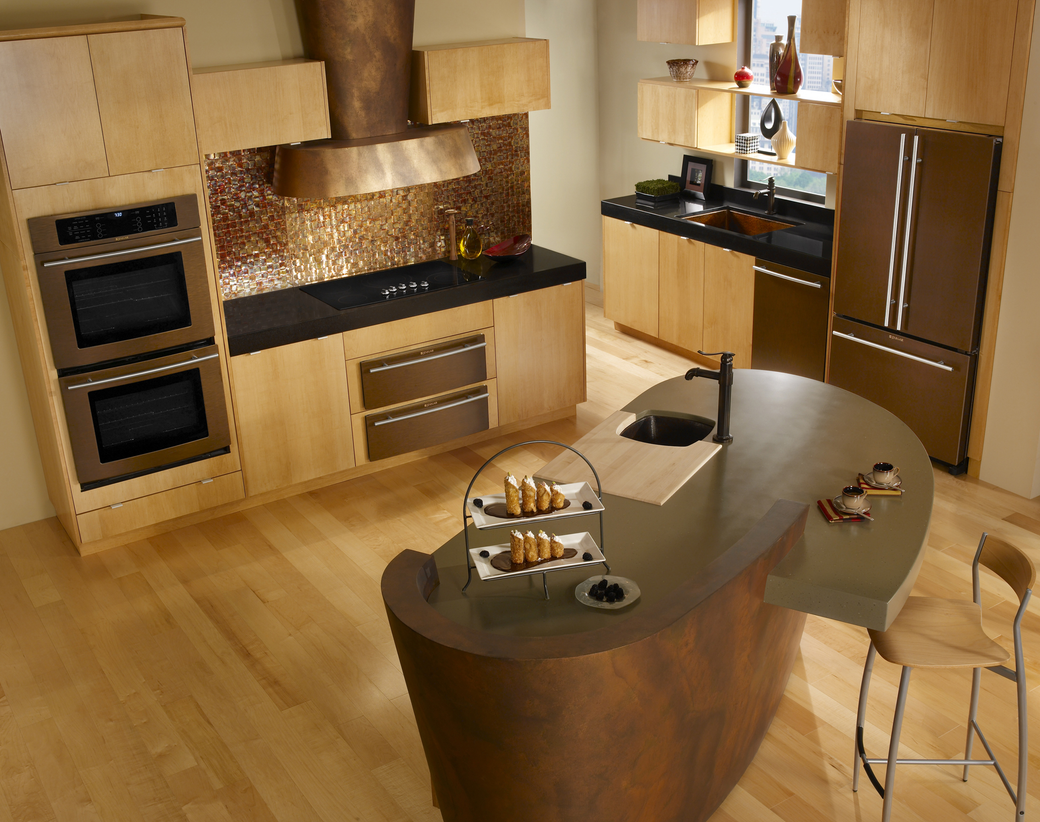 Modern wooden kitchen with island, built-in oven, stainless appliances, and a dining table with chairs.