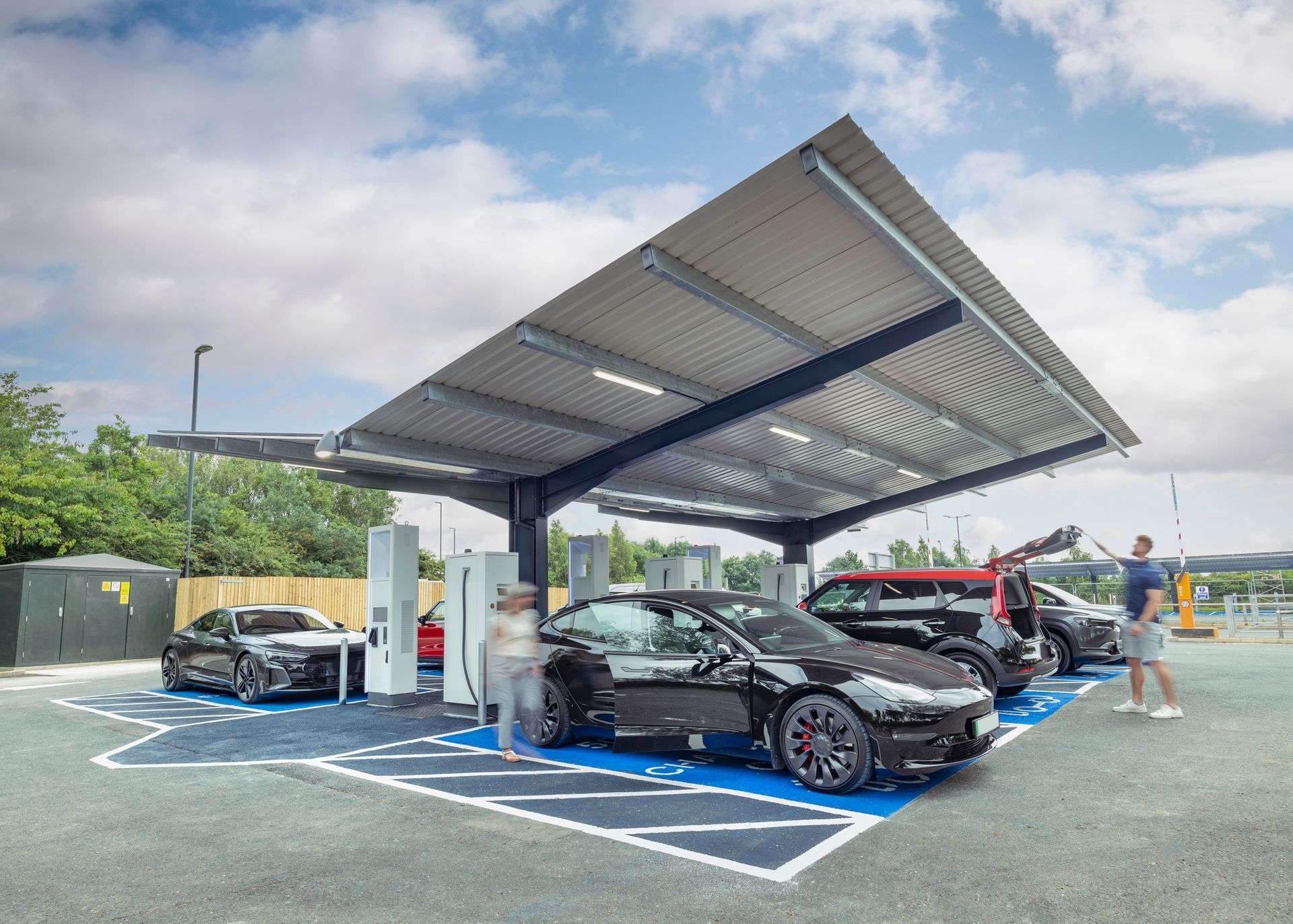 A couple of cars are parked under a canopy at a charging station – Milwaukee, WI - Best Electric Service