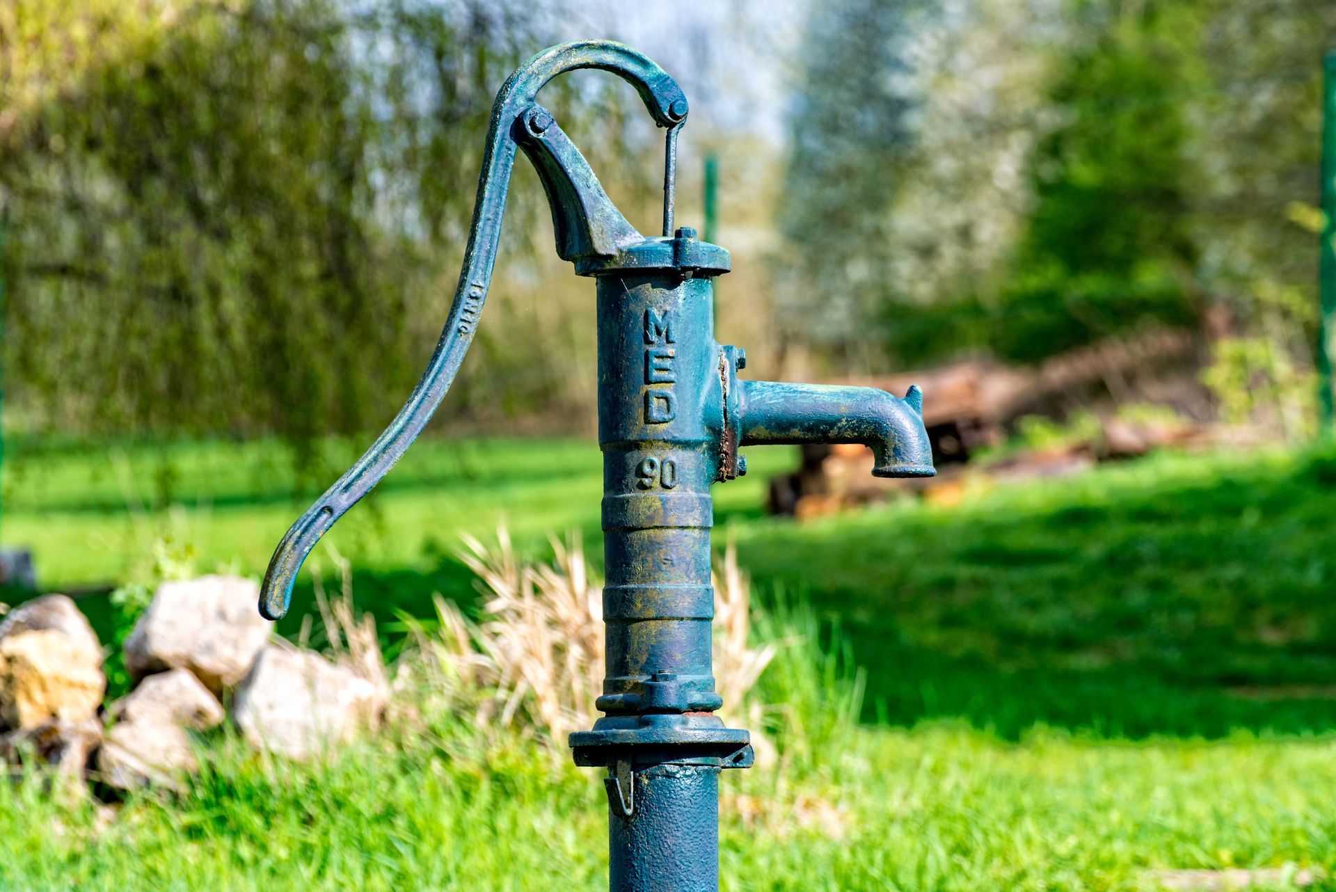 Traditional hand-operated water pump installed outdoors for groundwater access and use.