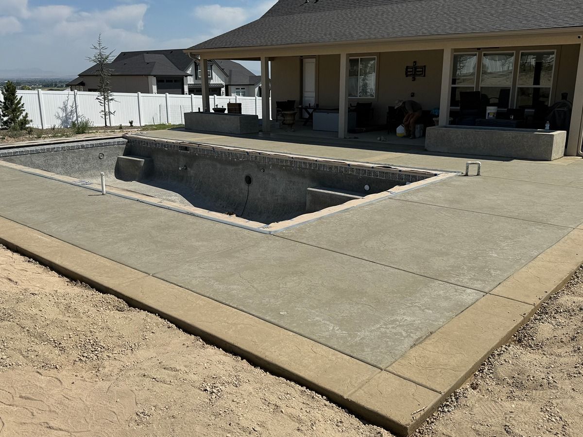 Concrete patio with a rectangular in-ground pool beside a covered outdoor patio area