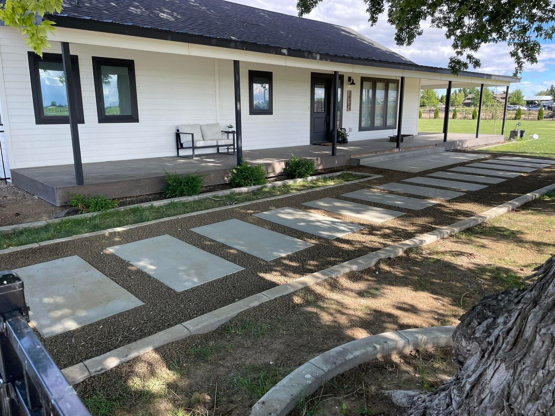 Modern house exterior with a stone stepping path and shaded porch area