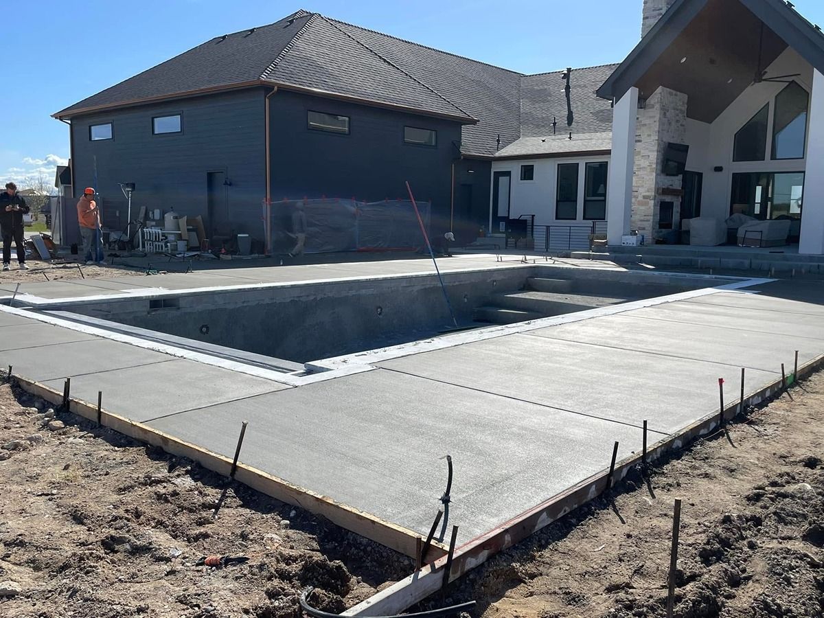 Concrete slab foundation at a construction site beside unfinished buildings