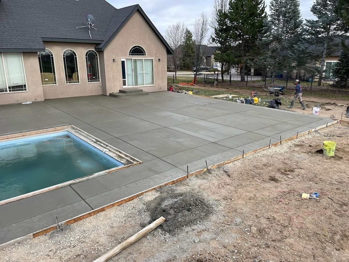 Backyard patio with pool beside a house, concrete pavers, and bare landscaping under construction