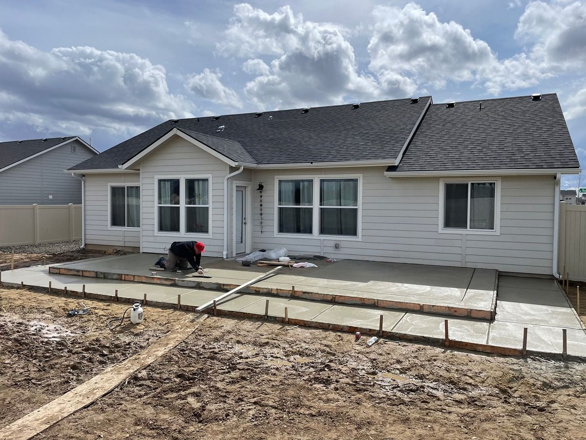 New single-story house with unfinished front yard and concrete walkway under a cloudy sky