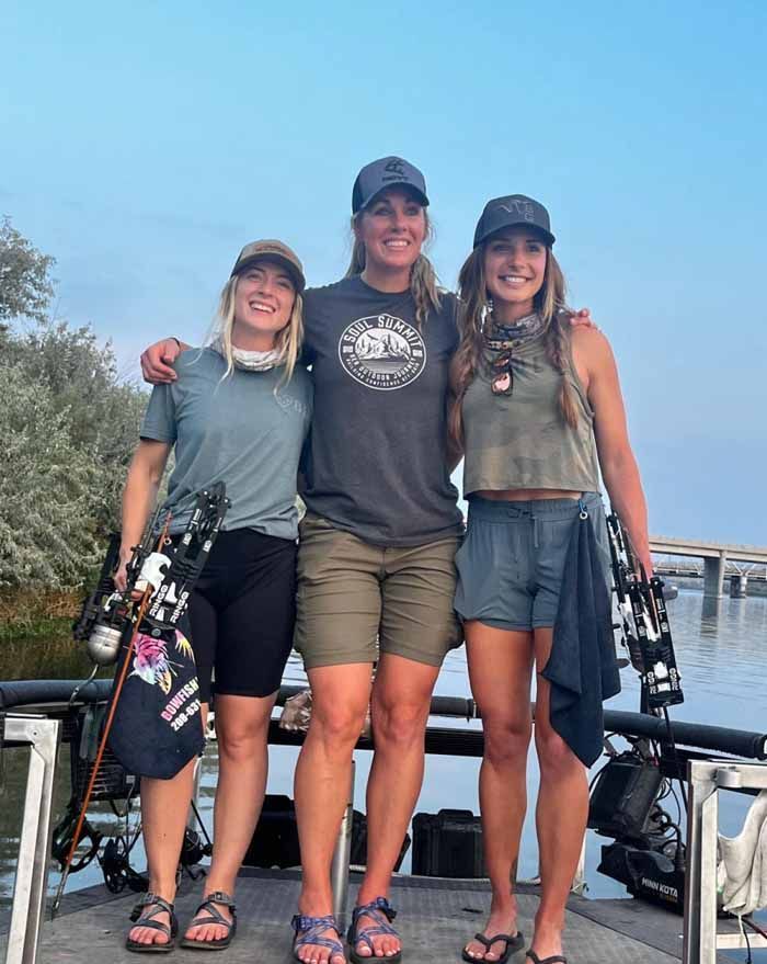 Three women are posing for a picture on a boat.