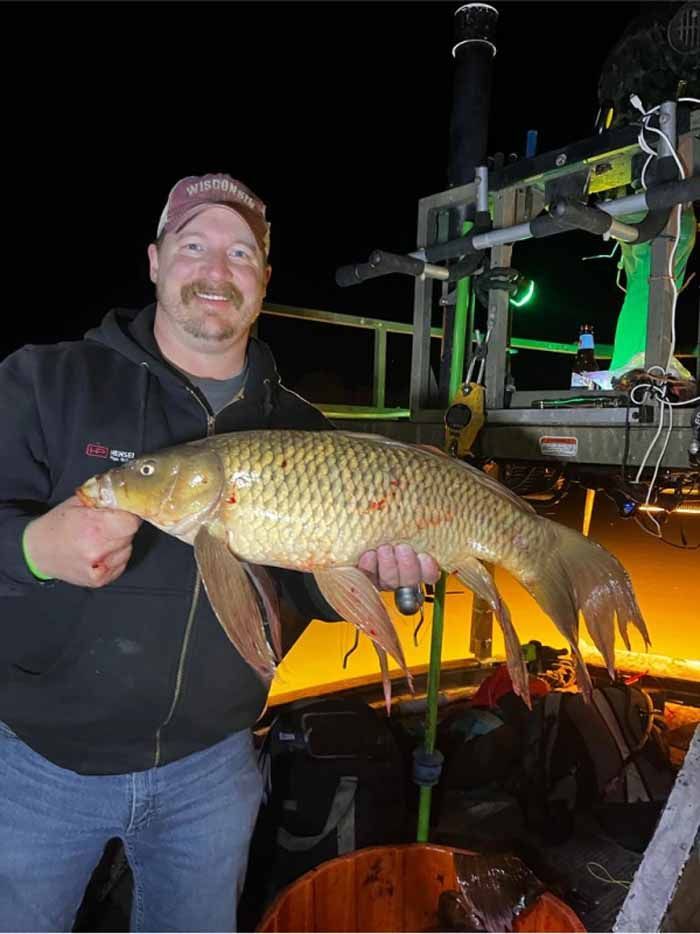 A man is holding a large fish in his hands