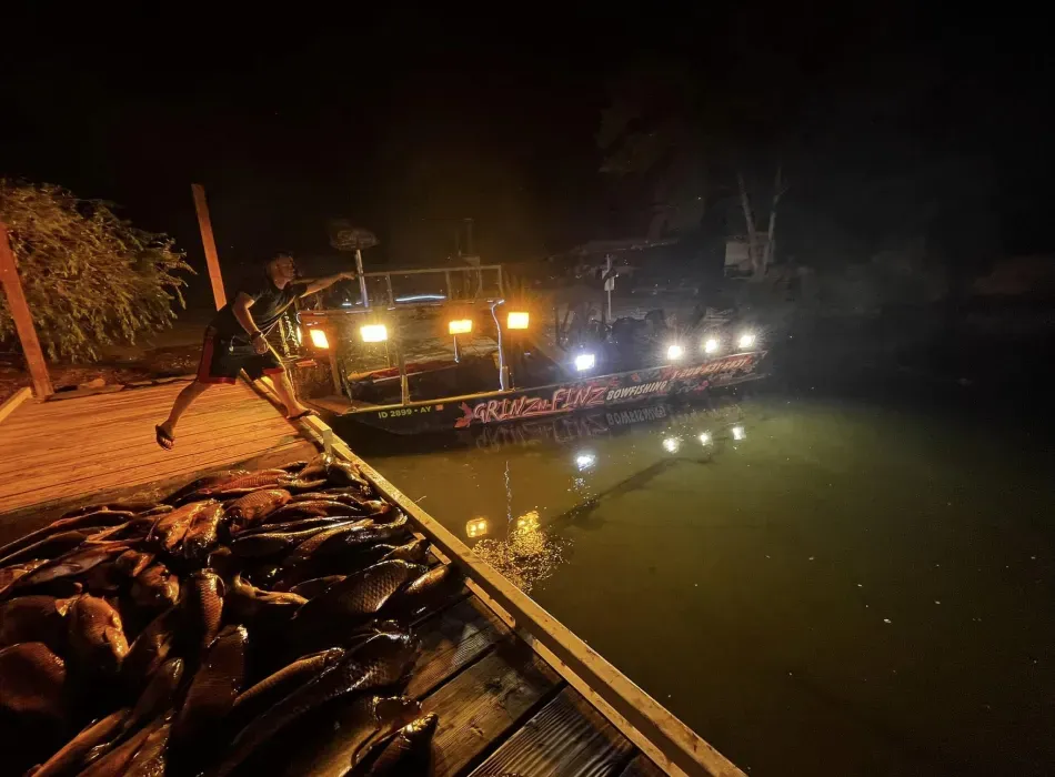 A man is jumping into a body of water at night.