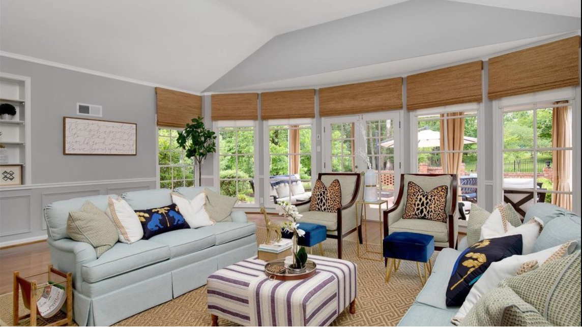 A living room with a fireplace and a window with wooden blinds.