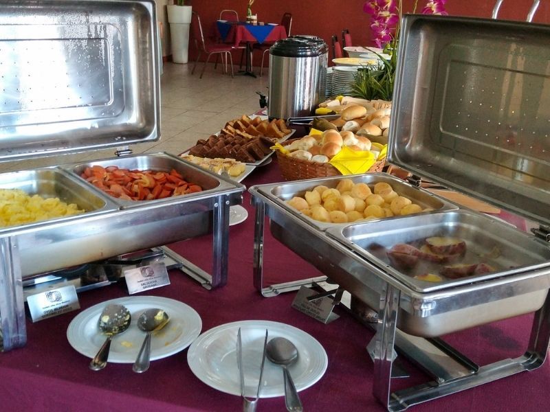 Mesa com ovos mexidos salsicha e pão de queijo