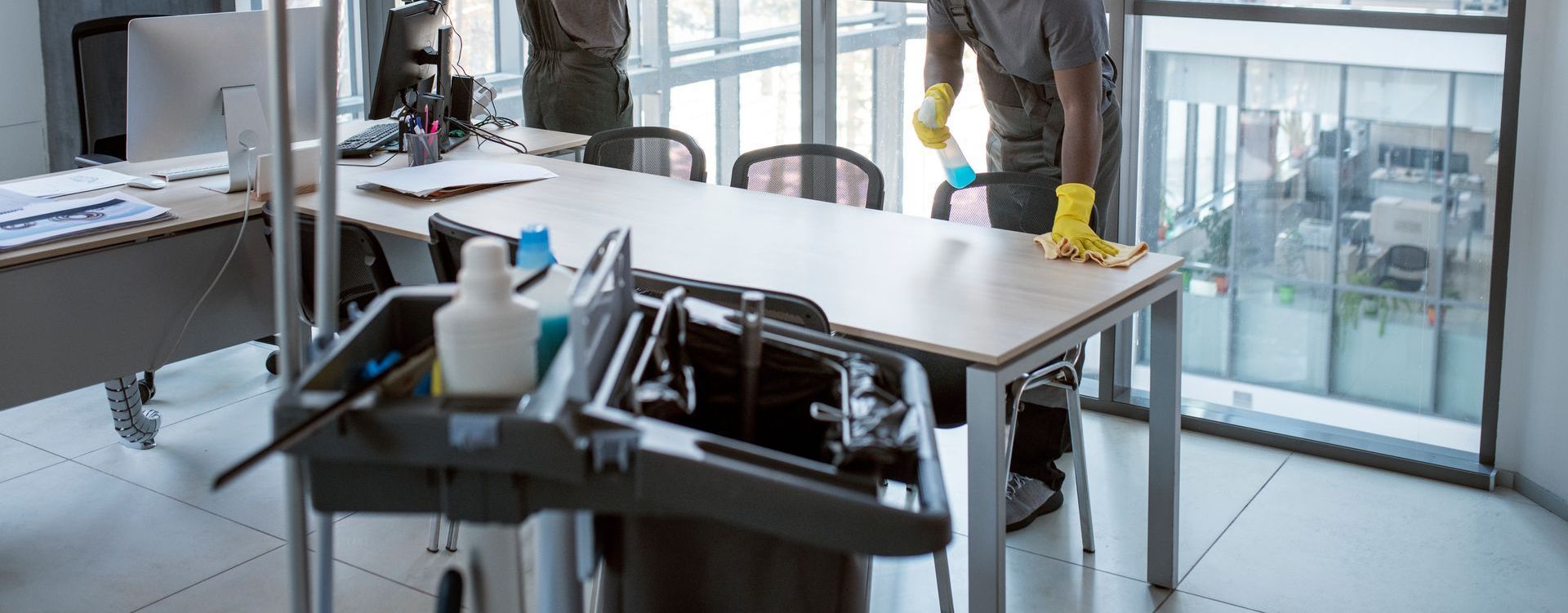 A man is cleaning a table in an office.