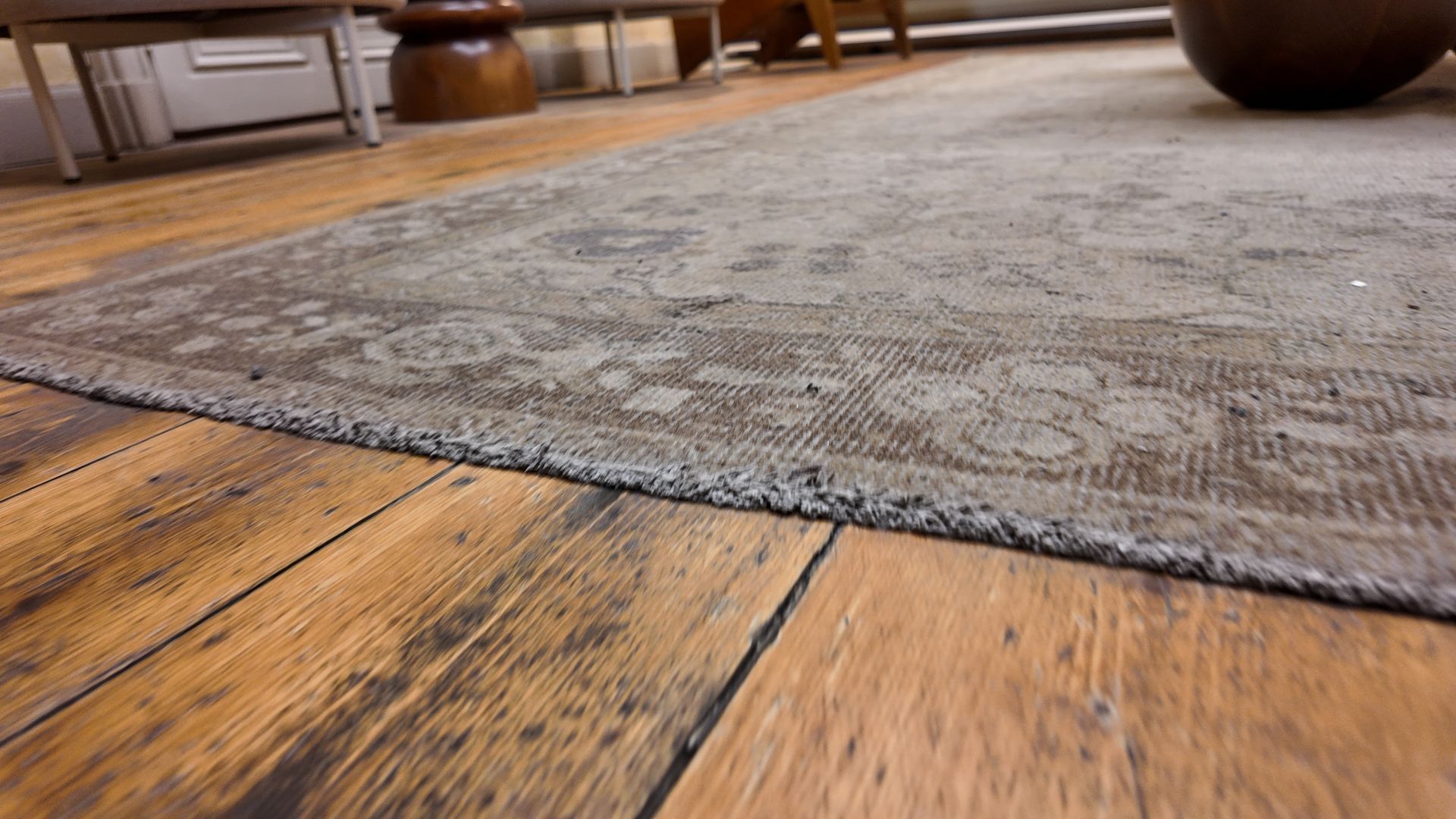 Close-up view of a dirty rug on wooden floor.
