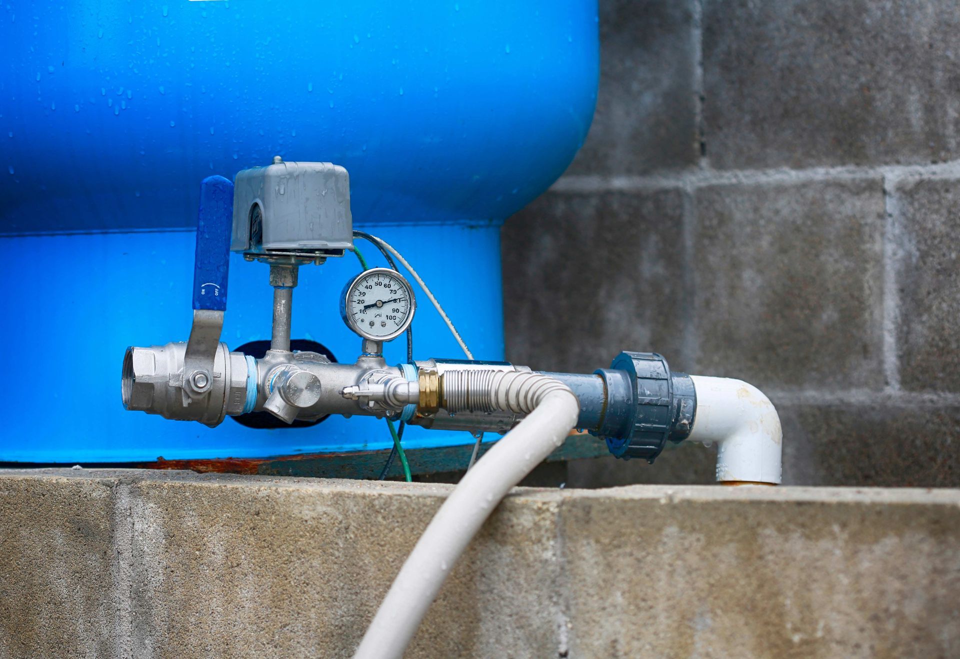 Close-up of a residential water well pump service manifold with pressure gauge and piping. Close-up of a residential water well pump service manifold with pressure gauge and piping.
