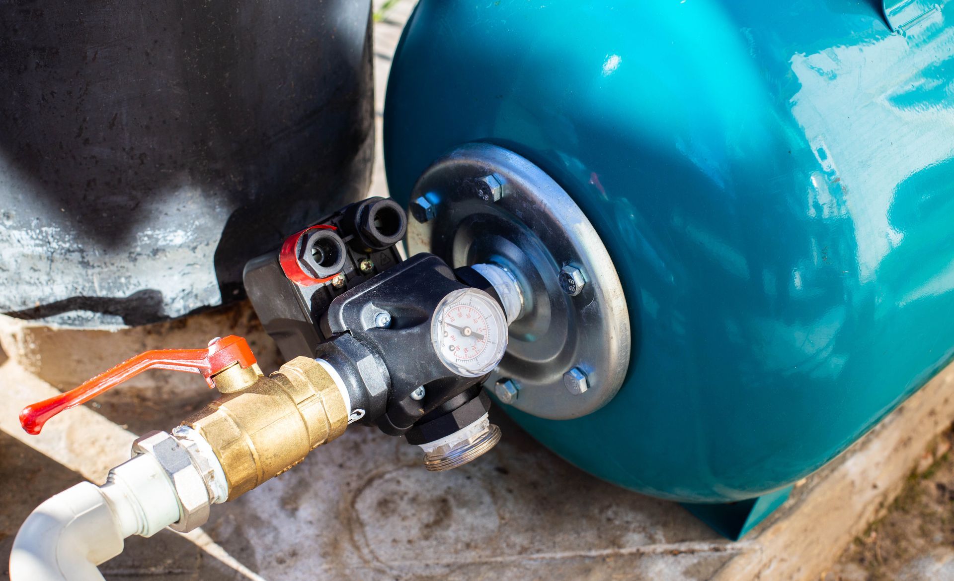 Close-up of a blue pressure tank and gauge for a professional water well pump replacement service.