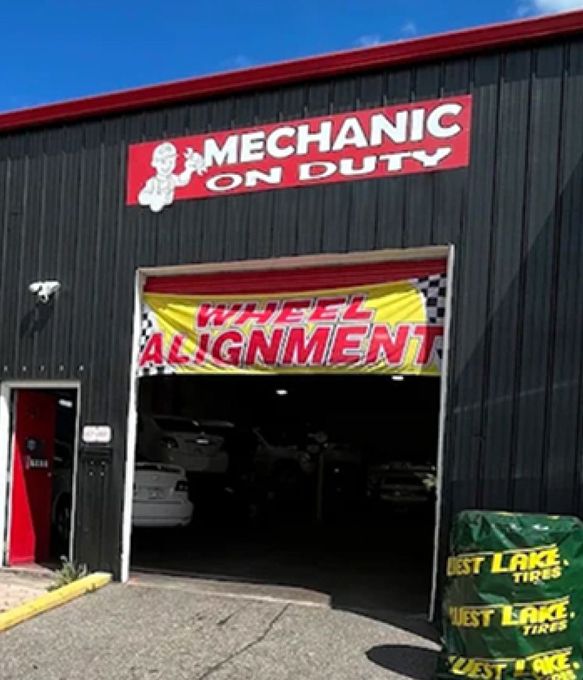 Auto repair shop exterior with “Mechanic on Duty” and “Wheel Alignment” signs above the garage entrance | Mechanic On Duty CB LLC
