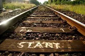 Railroad tracks with wooden ties marked “START” in the foreground, stretching into the distance.