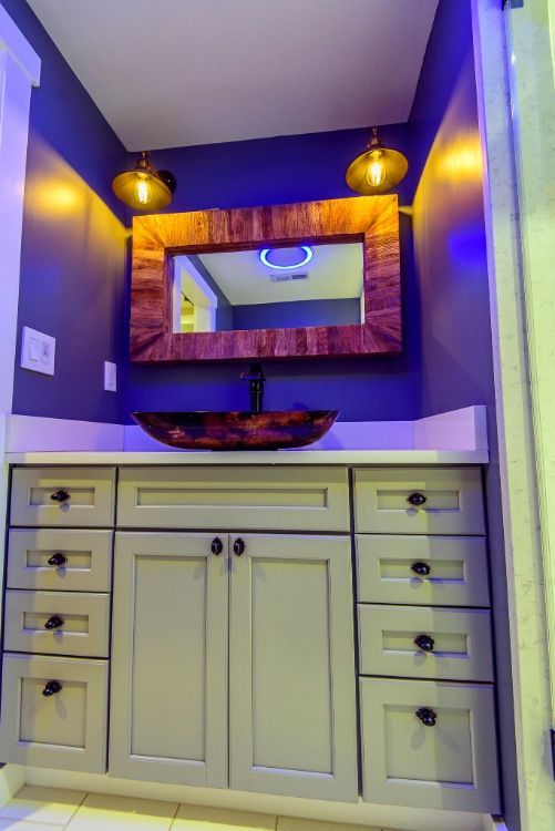Purple powder room vanity with white cabinet, mirror, and pendant lights