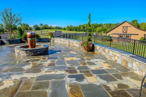 Suburban house with stone patio and walkway under a bright blue sky
