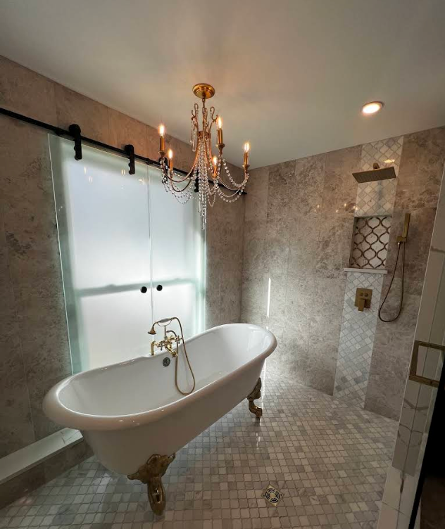 Luxury bathroom with freestanding clawfoot tub, walk-in shower, mosaic tile, and chandelier lighting