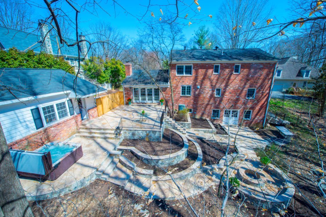 Courtyard between brick buildings with circular stone seating and bare trees in winter light