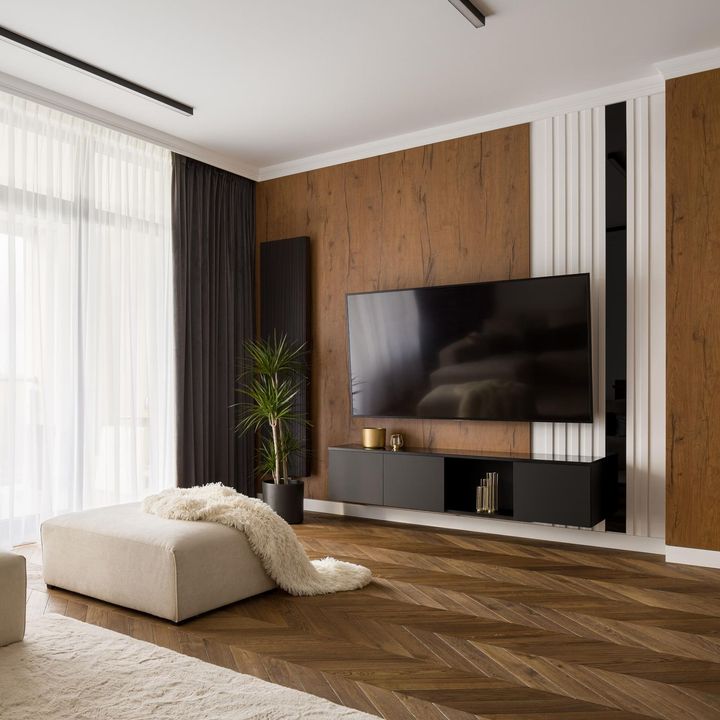 Modern living room with wall-mounted TV, wood accent wall, beige ottoman, and sheer curtains