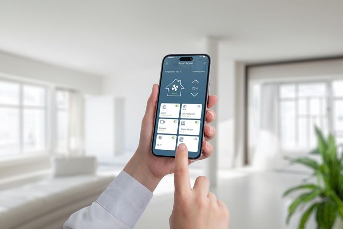 Hand using a smartphone home-control app in a bright living room