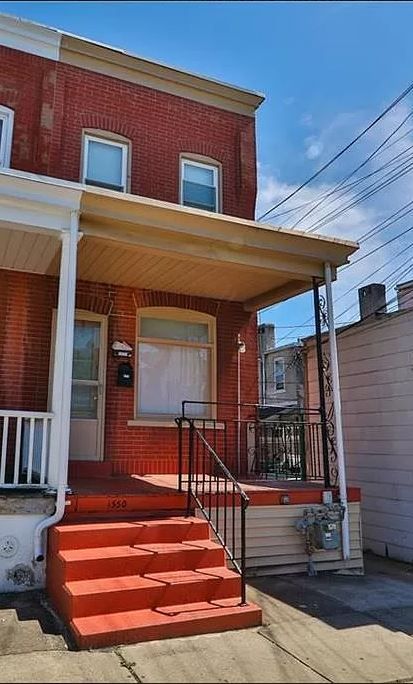 A red brick house with a porch and stairs