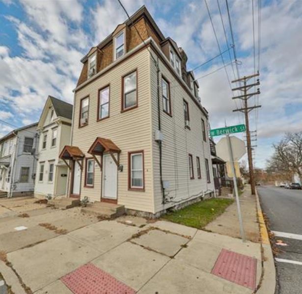 A corner of a street with a building and a sign that says brooklyn