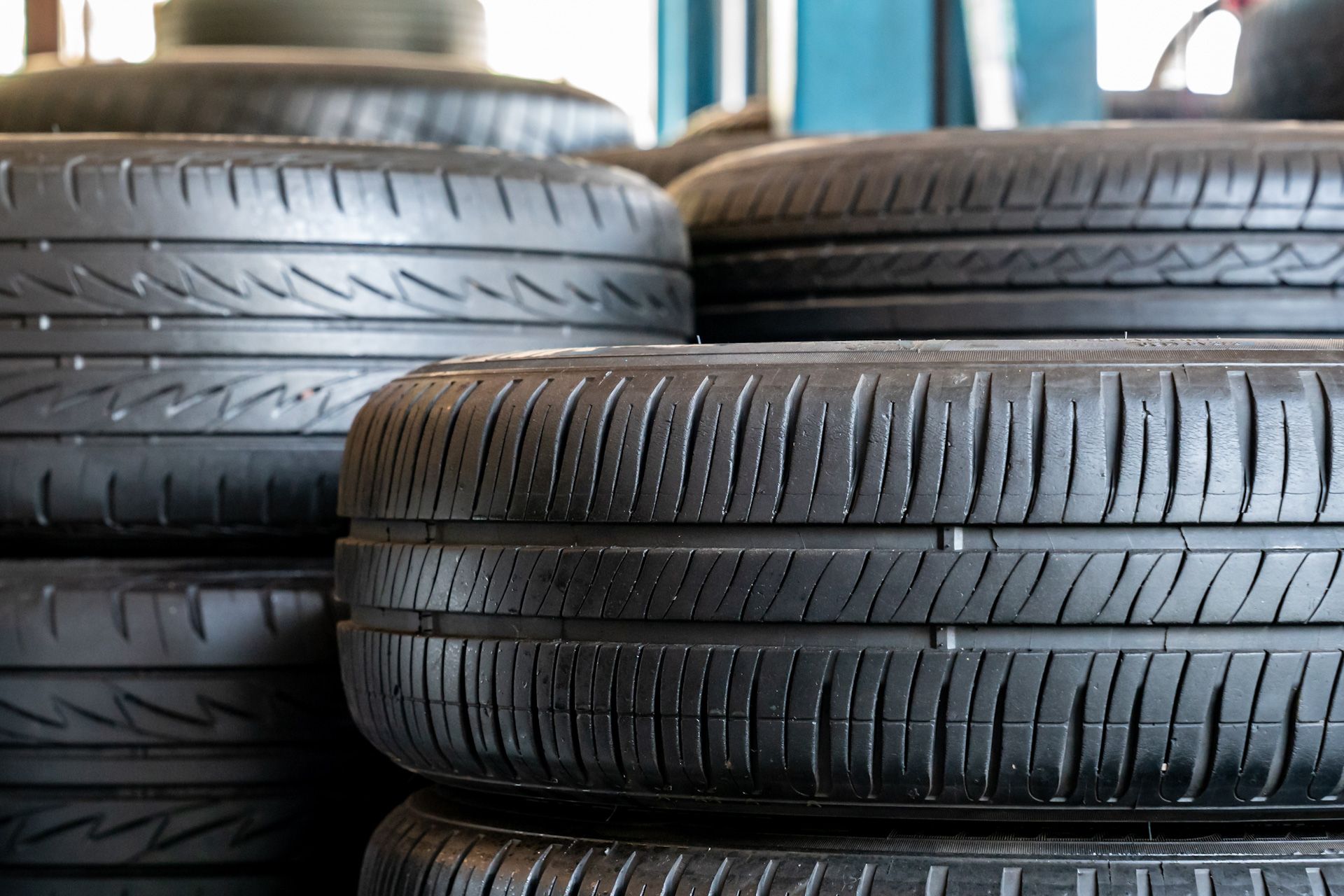 A pile of tires stacked on top of each other in a garage.