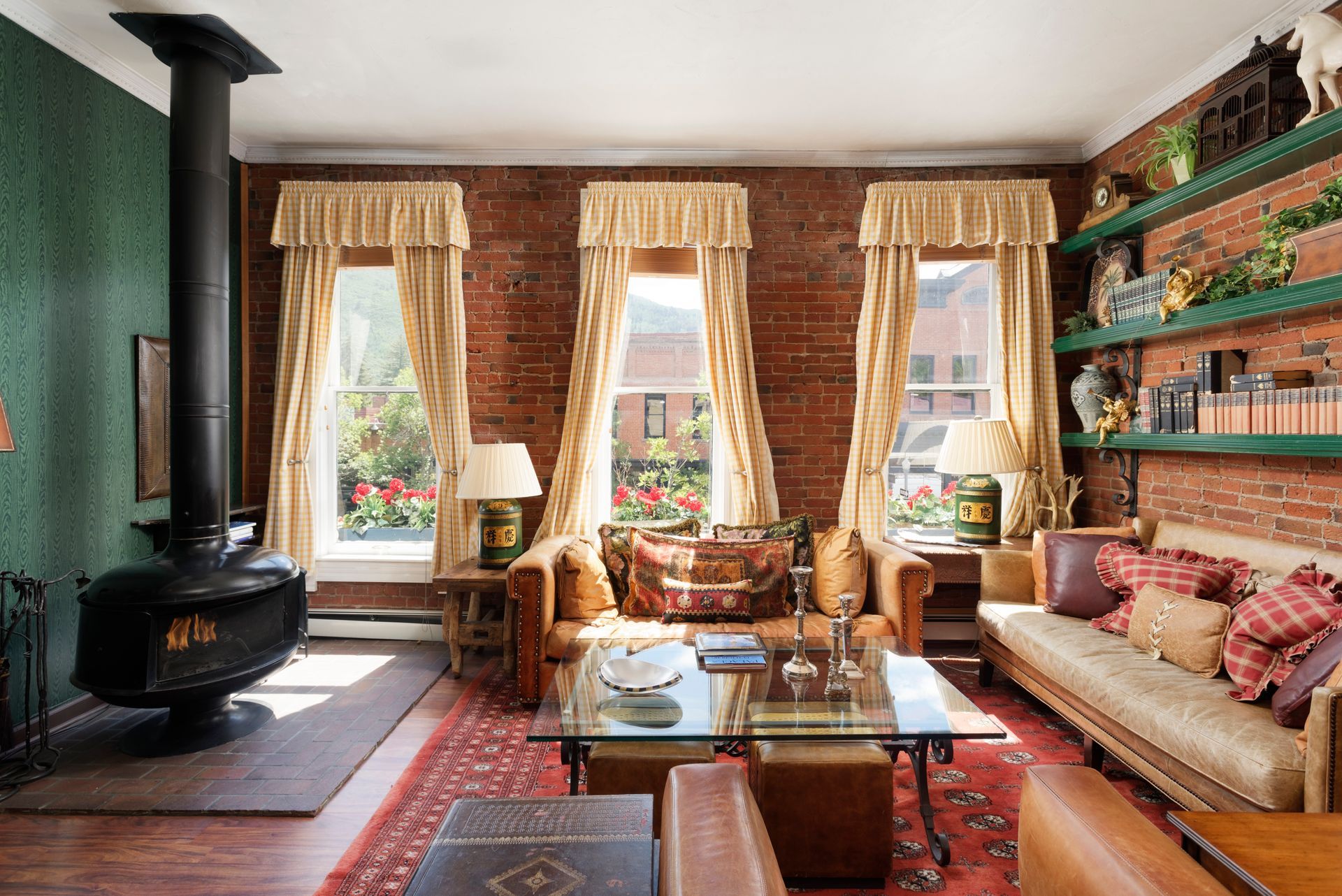 Living room with brick walls, ornate furniture, and a wood-burning stove.