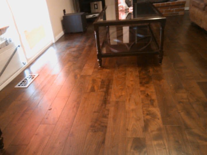 Wooden-floored living room with a glass coffee table and bright window light
