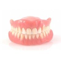 A close up of a denture on a white background.