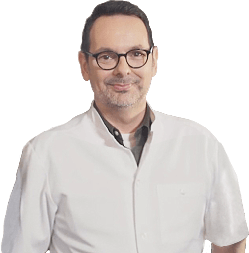 A man wearing glasses and a white coat is smiling for the camera.