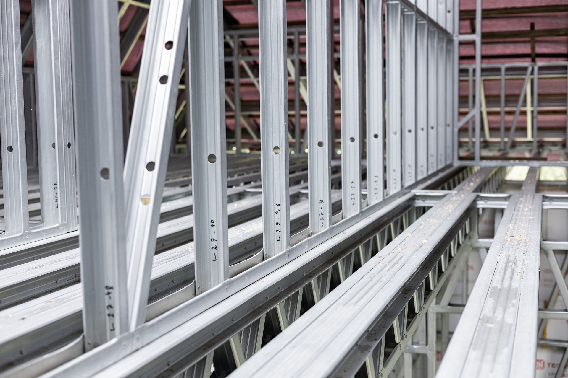 Steel building frame under construction with metal studs and floor joists.