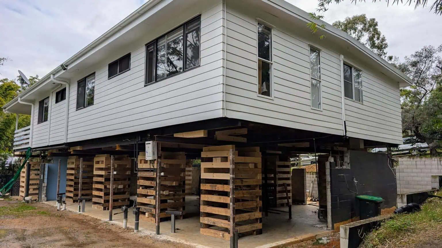 Elevated house on stacks of timber and supports during foundation work