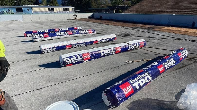 Rows of wrapped construction beams or pipes on a flat roof under bright sunlight