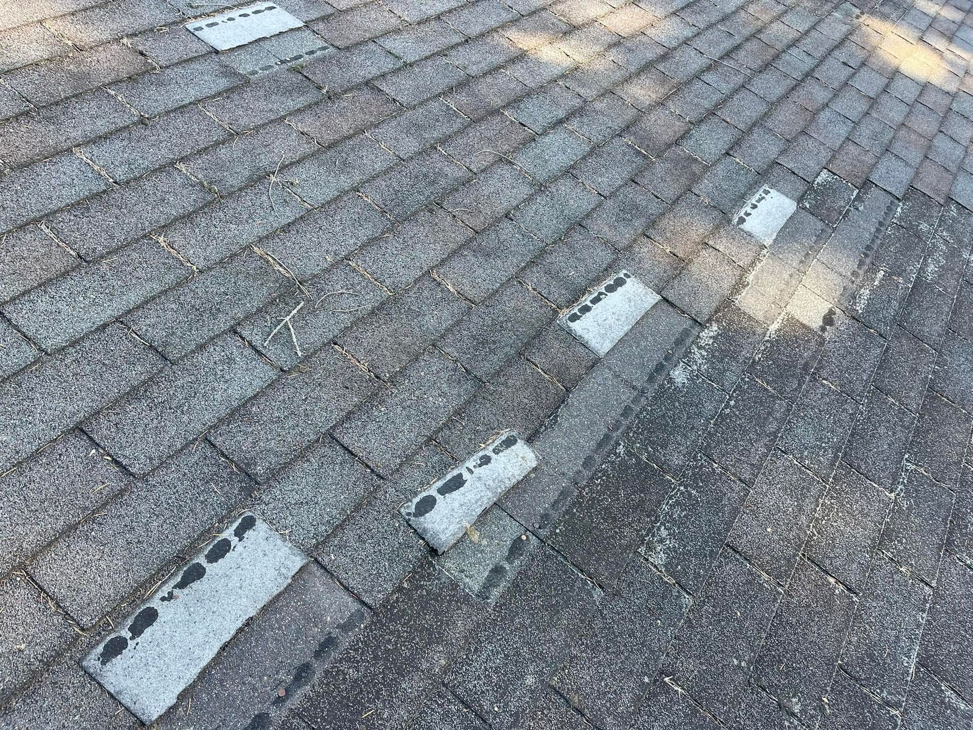 Gray shingle rooftop with missing shingles