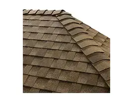 Brown shingle roof with overlapping asphalt tiles and a raised ridge line